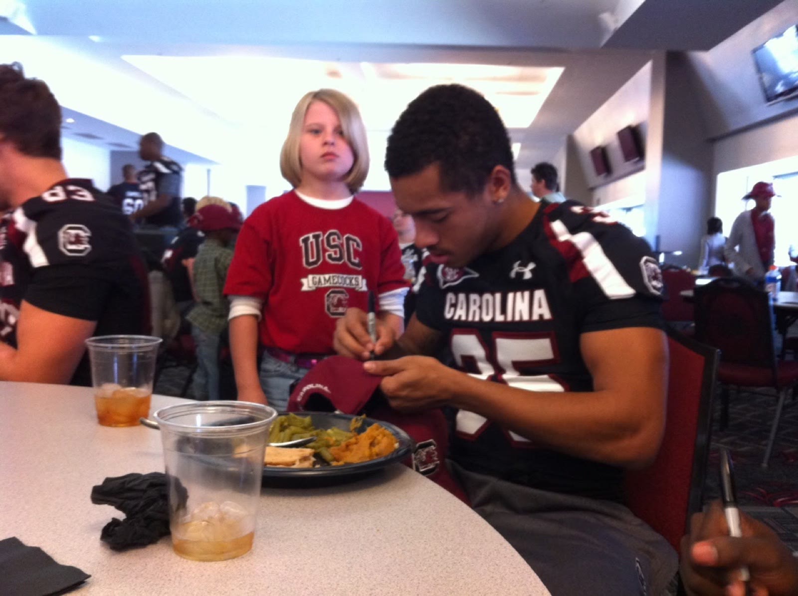 Ben Harvey signing an autograph for a young fan on gameday